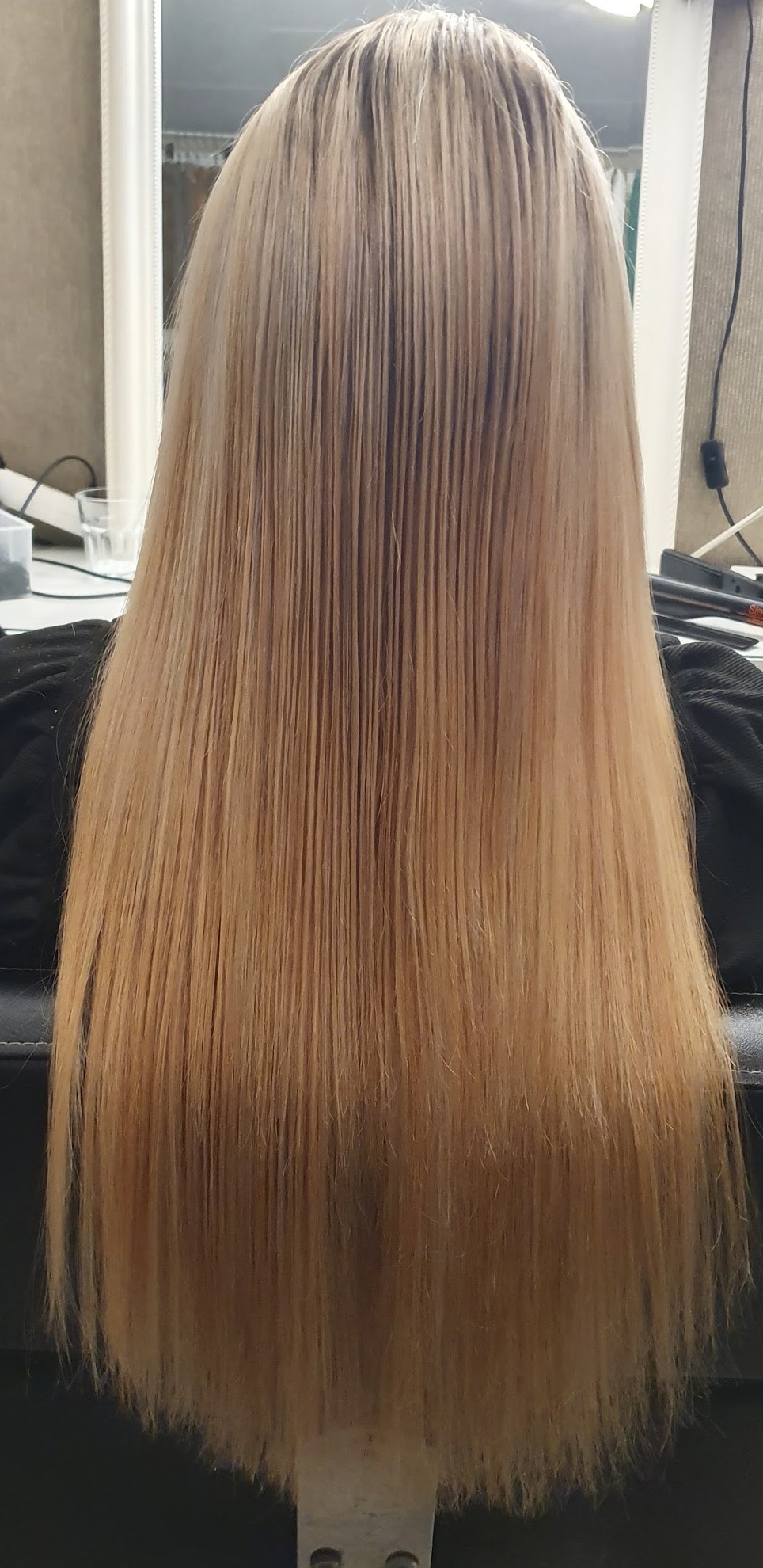 Na: lang, steil blond haar met een weave van 50 cm, van achteren gezien