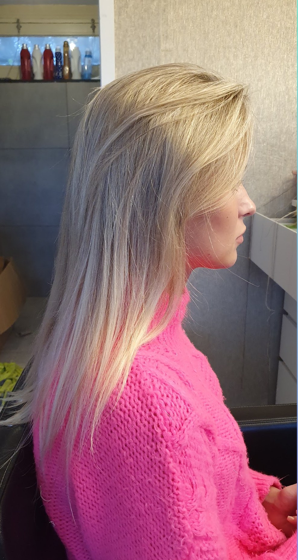 Voor: blond haar van opzij, klant in een roze trui