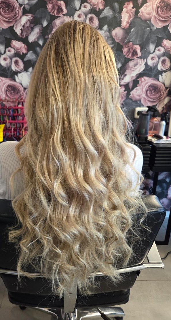 Lang blond haar met grote slagen, voor het rozenbehang in de salon