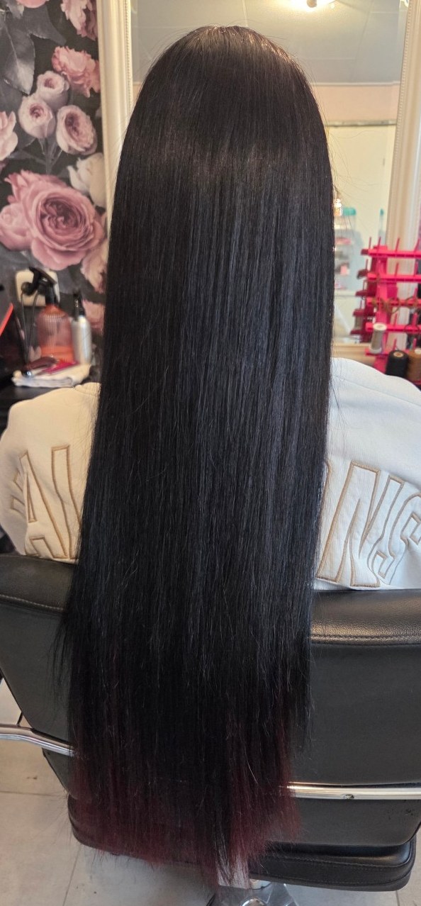 Lang, steil zwart haar tot onder de rugleuning van de salonstoel